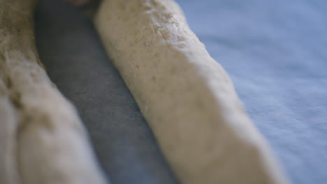primer plano de manos masculinas blancas colocando trozos de masa en papel para hornear