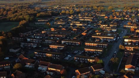 british neighbourhood housing establishing aerial view over early morning sunrise autumn coloured rooftops