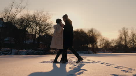 couple enjoying a snowy sunset stroll