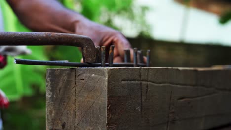 close up of carpenter using manual tools for bending metal in construction site