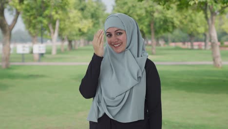 happy muslim woman doing adaab in park