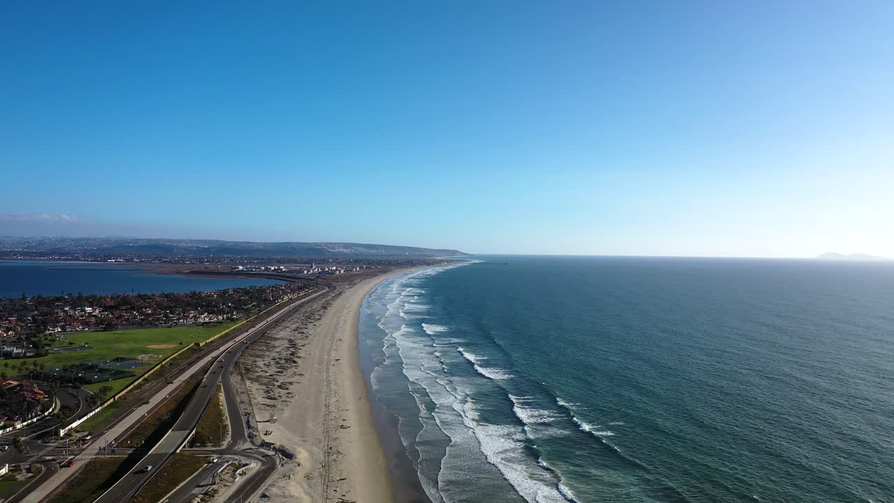 푸른 하늘과 함께 화창한 날에 바다와 해변에서 파도와 함께 황실 해변 부두를 마주하는 은색 해변에 대한 4k 공중 비디오