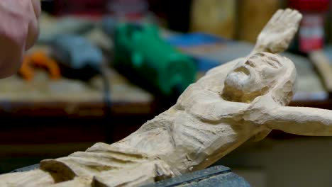 escultor italiano en su taller trabajando en una estatua de madera de olivo