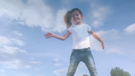 animation of clouds over smiling biracial girl jumping