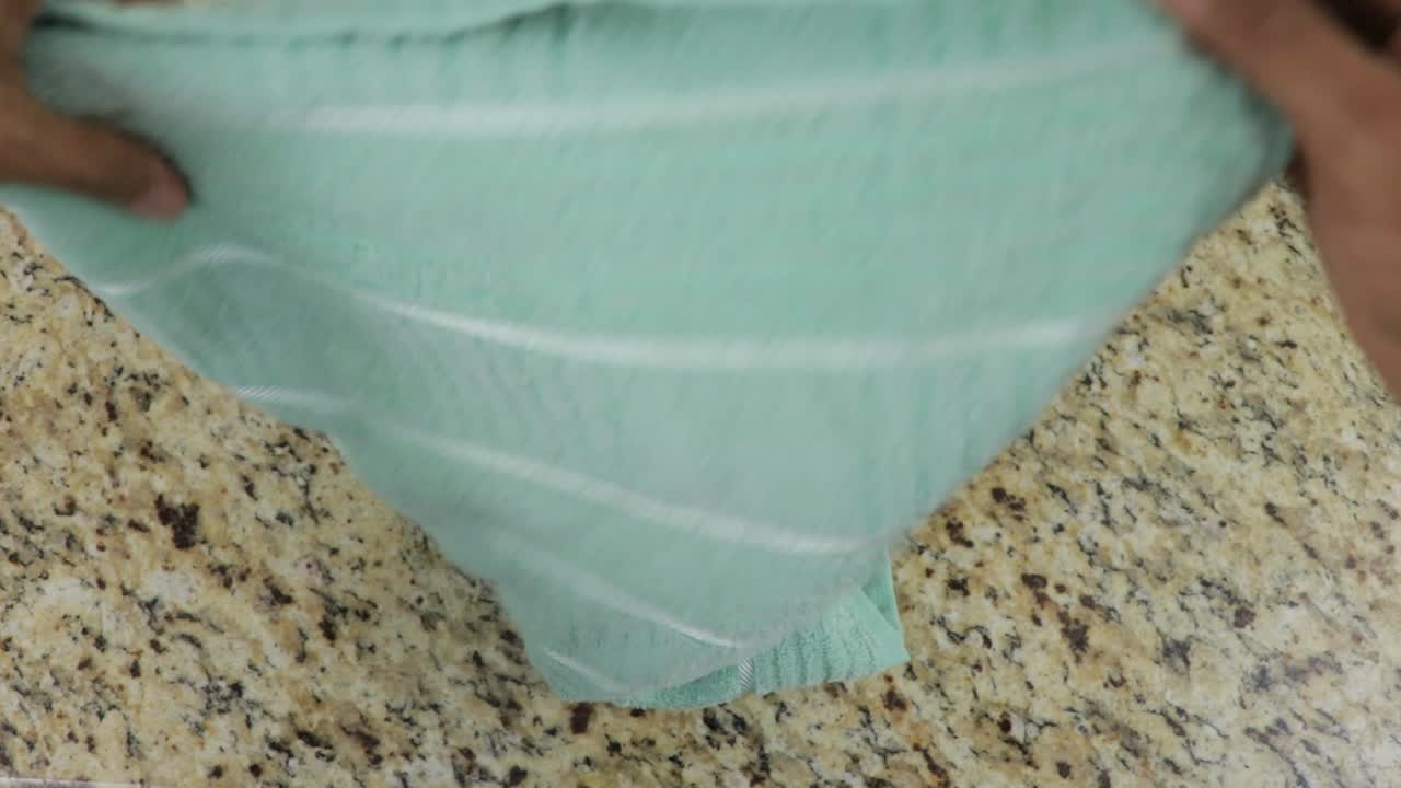 con las manos y la toalla verde plegable, vista de arriba hacia abajo