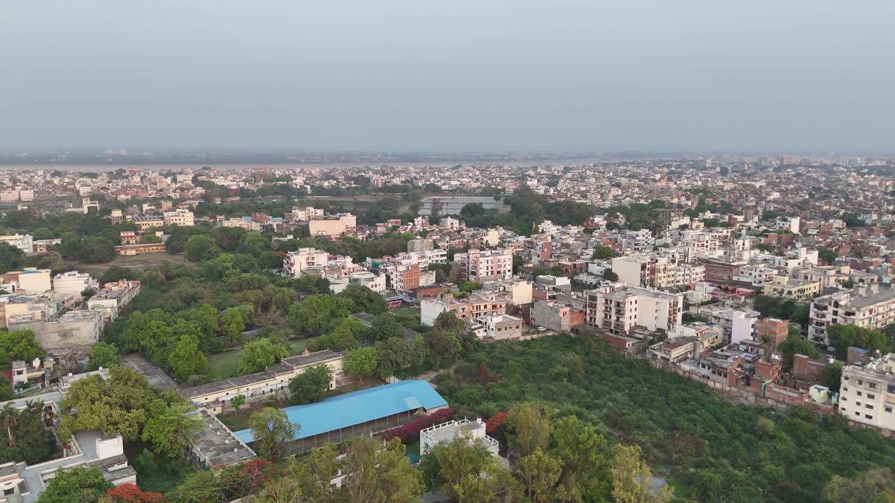 Drone capture of solar farm adjacent to residential buildings, presenting a contrast between technological innovation and traditional architecture