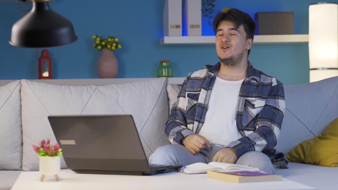 시험 결과가 좋다는 것에 행복한 남성 학생. 밤에 집에서.