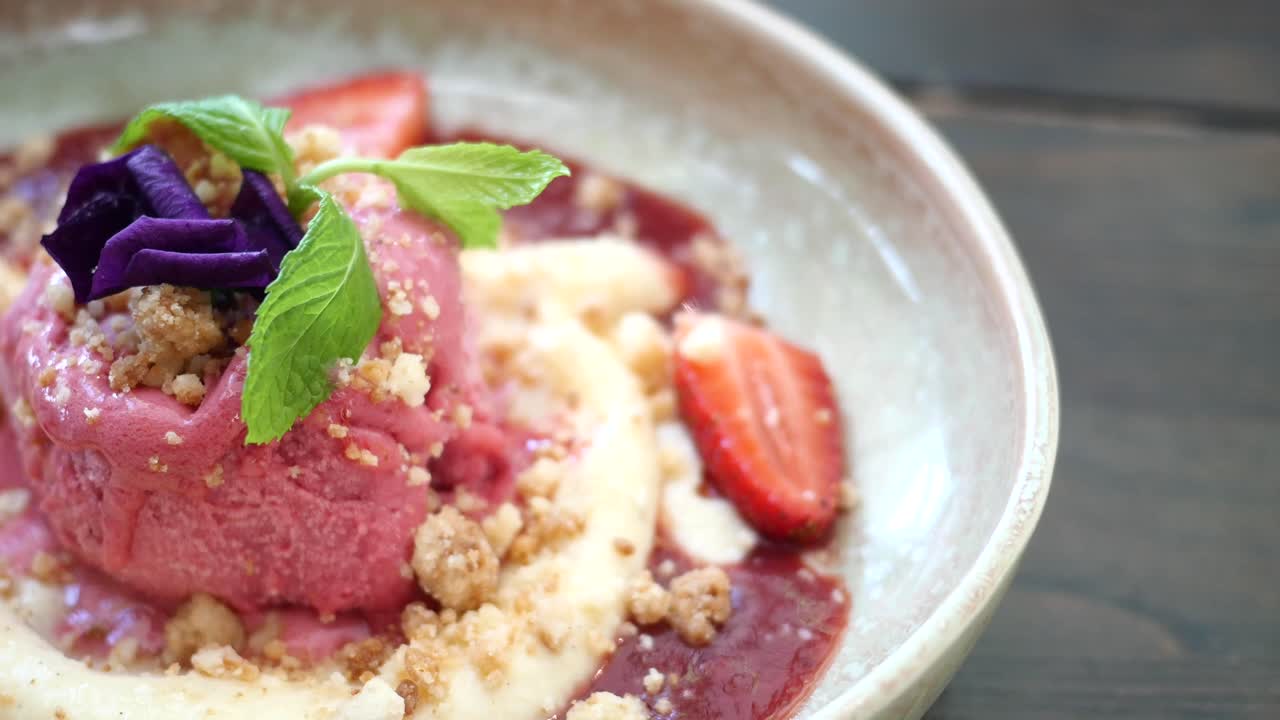 Strawberry ice cream dessert with crumble and flower garnish