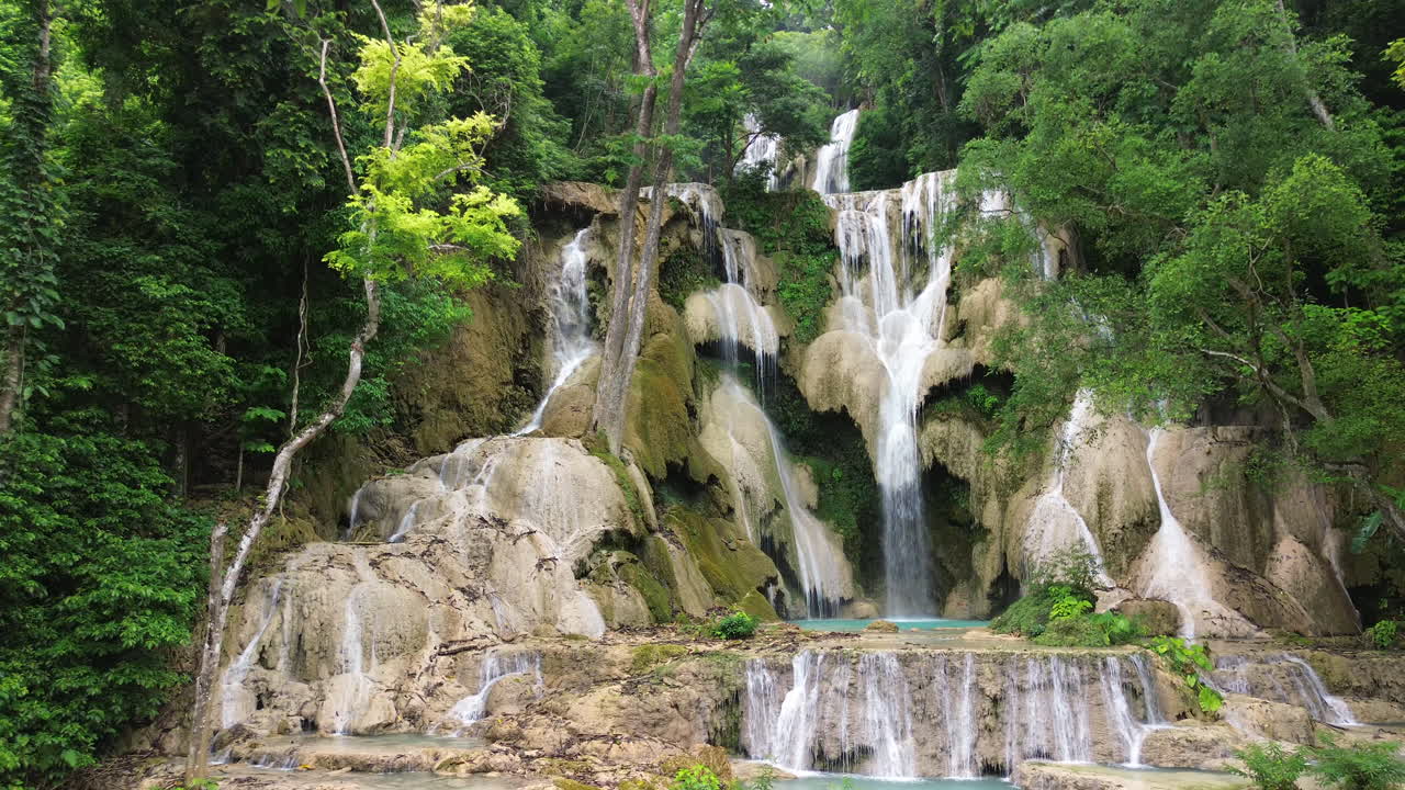 Cascata a più livelli che sfocia in pozze di un blu brillante circondate dalla foresta, Kuang Si Luang Prabang Laos.