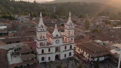 famosa iglesia de san cristobal en el pueblo mágico de mazamitla, jalisco, méxico al atardecer - toma aérea giratoria