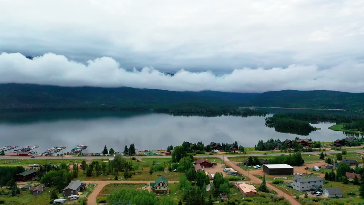 vista aérea de drones del hermoso embalse de la montaña sombra en un día nublado de verano en el gran lago de colorado con coches que conducen en la carretera a lo largo de las casas de vacaciones pasadas la costa nublada