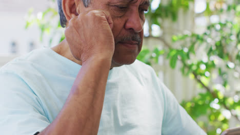 Hombre-De-Raza-Mixta-Senior-Concentrado-En-Tablet-PC-En-El-Jardín