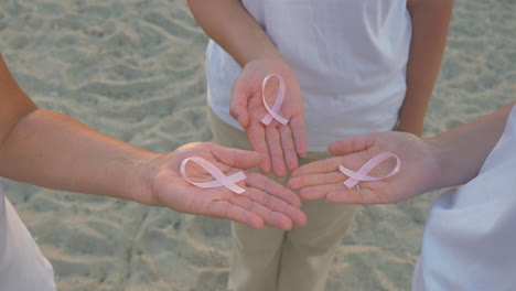 three women with pink awareness ribbons