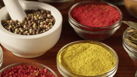 various spices in glass bowls close-up. middle eastern and arabian culture. seasoning and flavors. pepper, coriander, cinnamon, turmeric, paprika, cumin. different kinds of dry herbs for cooking.