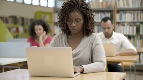 front view of serious african american woman using laptop