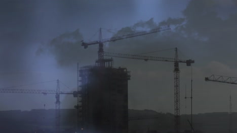 grúas en la parte superior de un edificio y relámpagos
