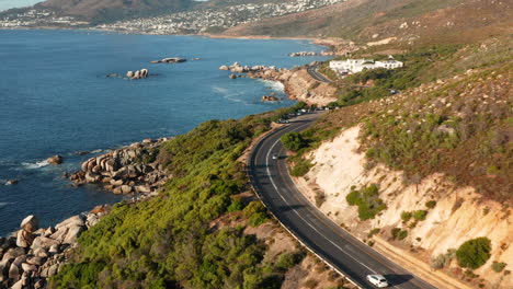 car driving through victoria road at sunset in oudekraal, south africa