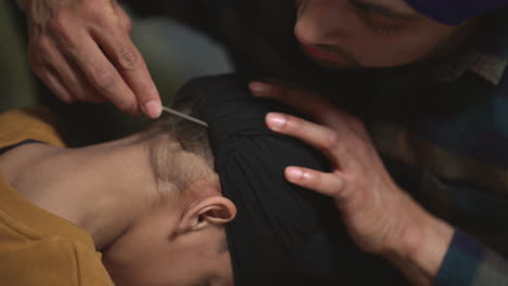 Close-Up-Of-Father-Using-Salai-Needle-To-Tidy-Away-Hair-When-Tying-Turban-Onto-Head-Of-Young-Sikh-Son-Shot-in-Real-Time