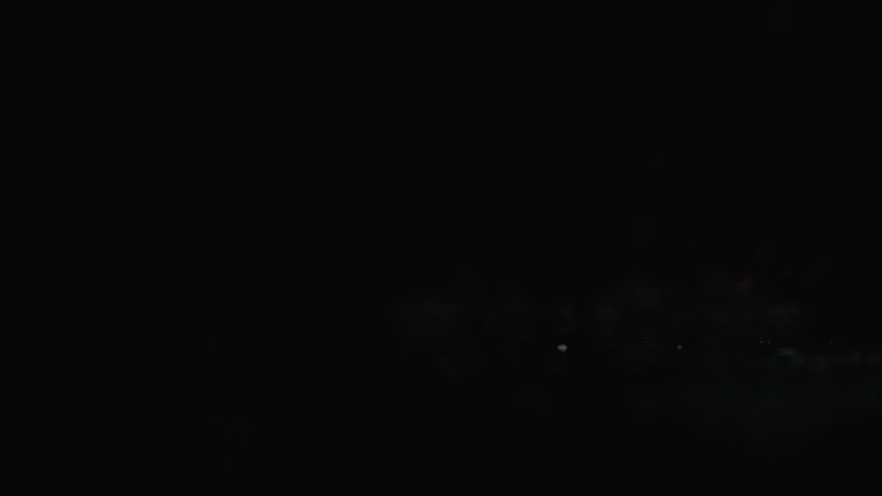 몇 개의 은 익은 토마토가 어두운 배경에 천천히 물을 는 유리잔에 떨어집니다.