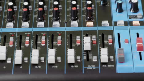 primer plano de un dedo presionando un botón en un mezclador de audio