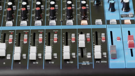 closeup of a finger pushing a button on an audio mixer