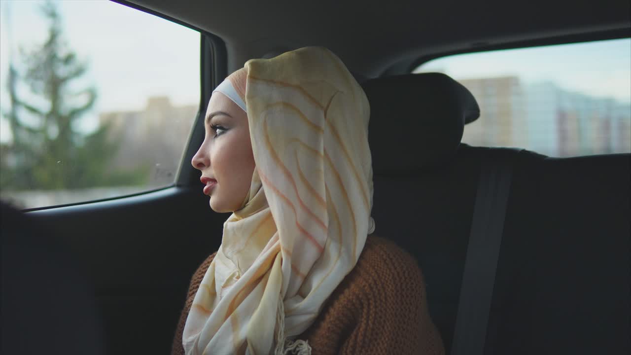 Woman in Hijab Looking Out Car Window