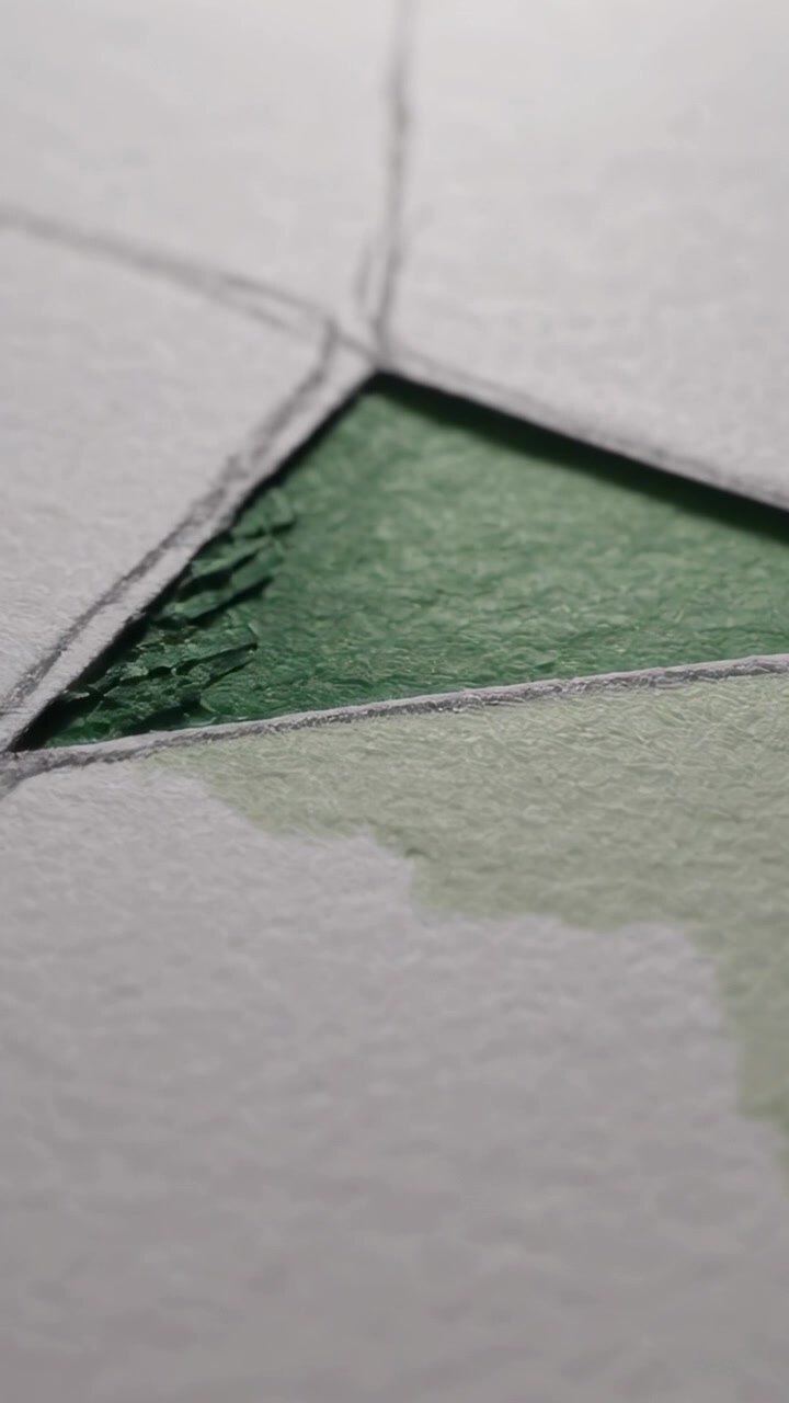 Vertical video: Shifting cam zooming in on textured paper green triangle, revealing pencil lines