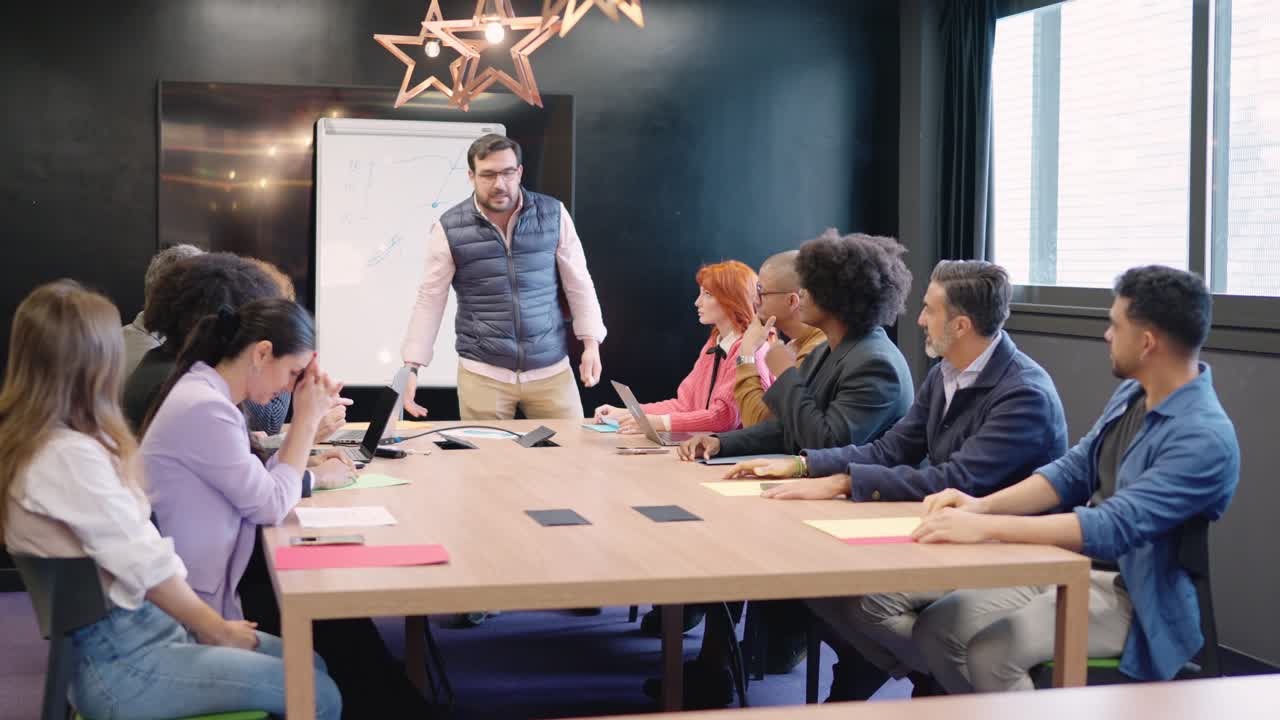 Boss scolding a work team in a meeting room