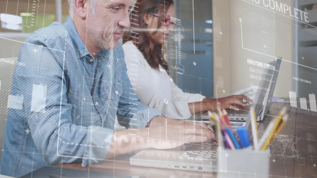 Working on laptops, two people with data processing animation over them