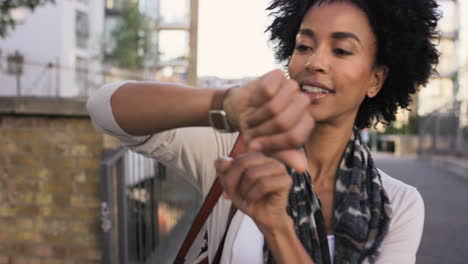 Schöne-Frau-Mit-Gemischter-Abstammung,-Die-Mit-Smartwatch-Technologie-Durch-Die-Stadt-Spaziert