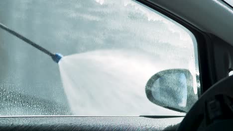 Chorro-De-Agua-Limpiando-La-Ventana-Del-Coche-En-Cámara-Lenta