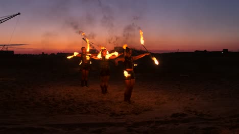 fire show. a group of professional artists performs a variety of fire facilities. boys and girls performed dances with fire in the night on the street in the park.