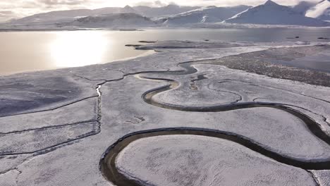 aerial views capture iceland's borgarfjörður region, showcasing its tranquil fjord, snow-capped mountains (hafnarfjall, kessuhorn, baula), ice formations, waterfalls, and rugged volcanic landscapes