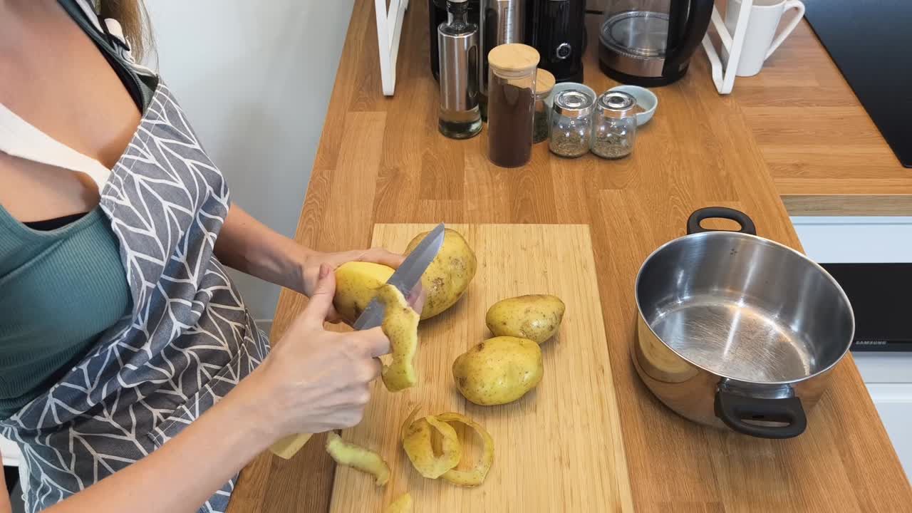 mujer pelando patatas en la cocina