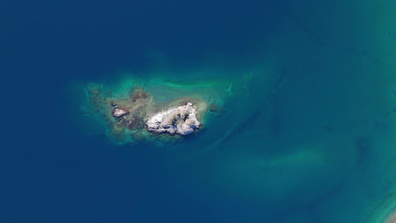 Aerial view of a rocky islet in turquoise waters of Lake Nahuel Huapi, Patagonia, Argentina