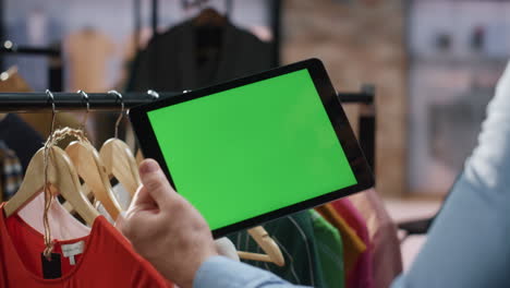 las manos del hombre mirando el modelo de la tableta recopilan datos de producción en el primer plano de la boutique