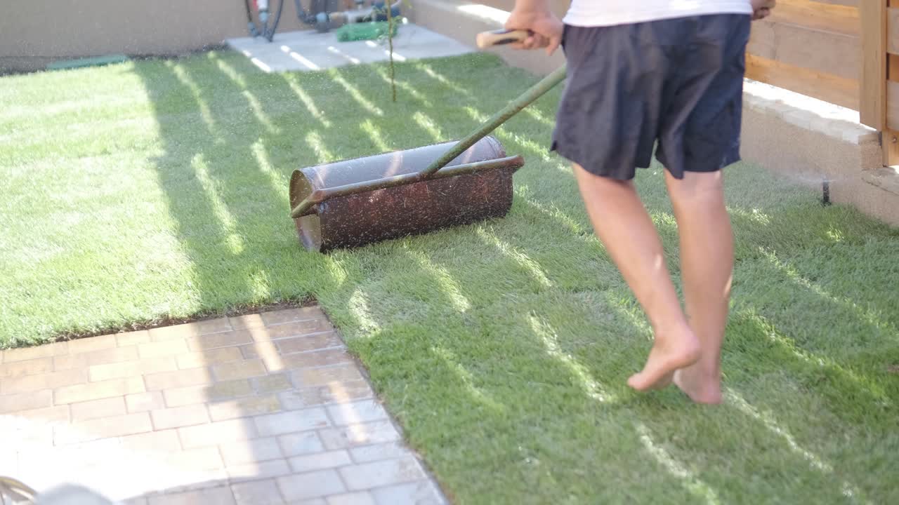 정원사 가 자연 잔디 잔디 를 굴러 놓고 있다