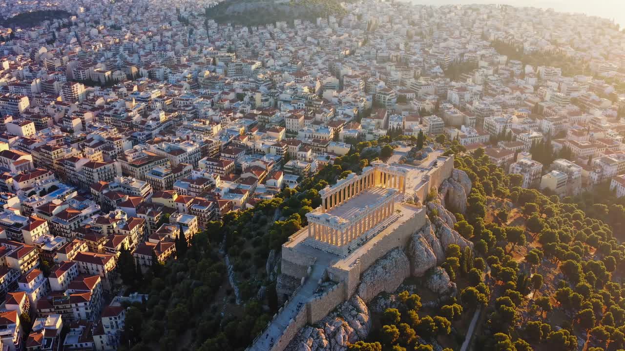 Aerial video view of ancient ruins atop a hill surrounded by a sprawling cityscape