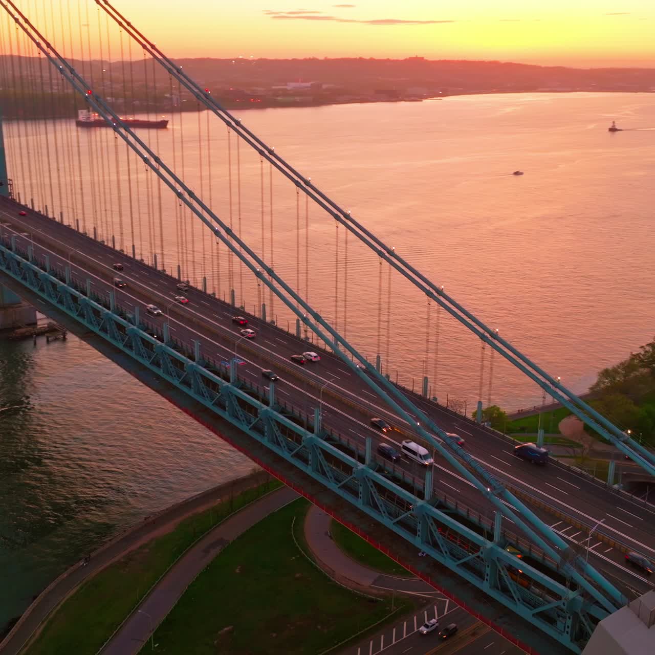 Amazing sunset coloring everything in pink. Whitestone bridge with fast moving cars over East river