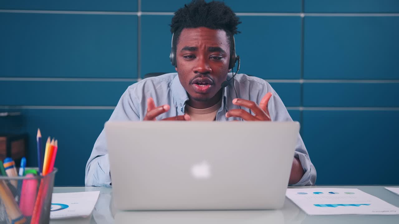 Junger afroamerikanischer Mann telefoniert per Videoanruf mit Headset