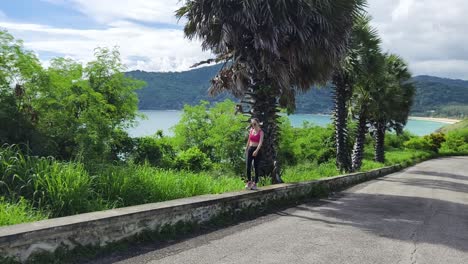 woman walking along a coastal road