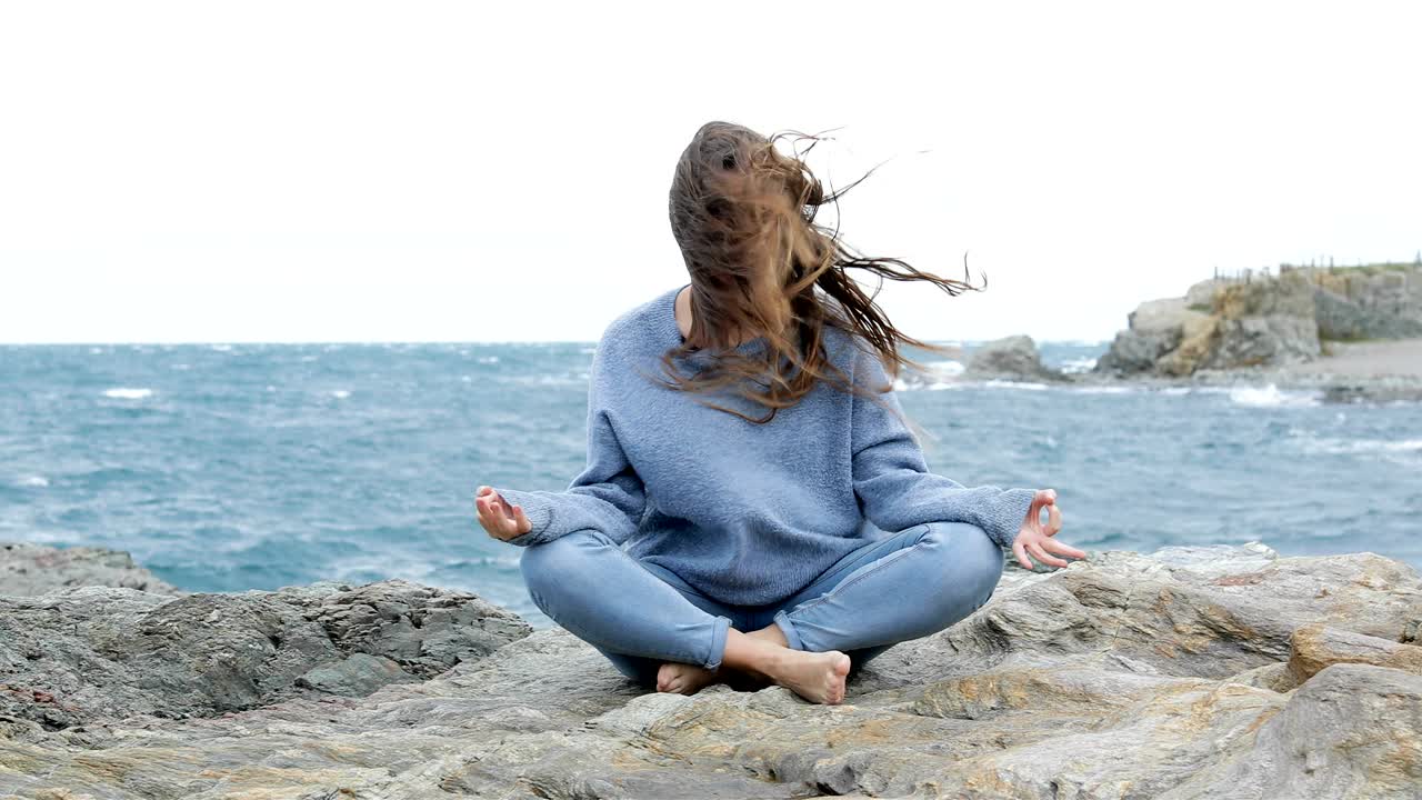 mujer enojada tratando de practicar yoga en un día de viento