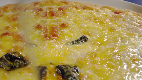 toma macro cortando pizza con queso y salsa de tomate
