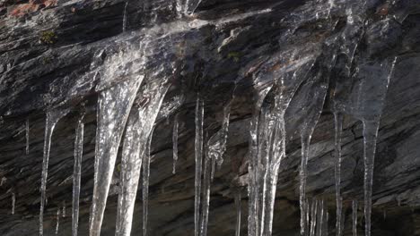 Zartes-Gitter-Aus-Schmelzenden-Eiszapfen-Händen-Aus-Dunklen-Verdorrten-Felsen