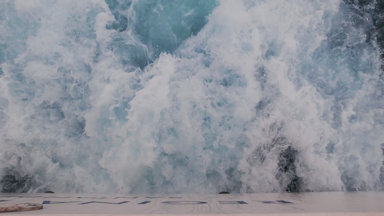 agua de mar espumosa blanca que sale del ferry con motor a reacción vista de la bahía de santander desde un ferry durante el atardecer del día nublado de verano