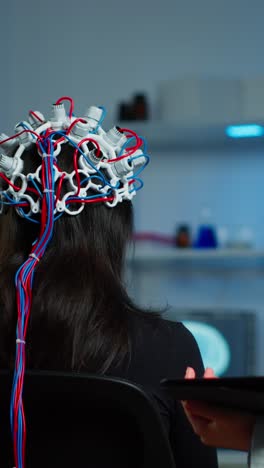 doctor adjusts eeg cap on patient's head in a laboratory