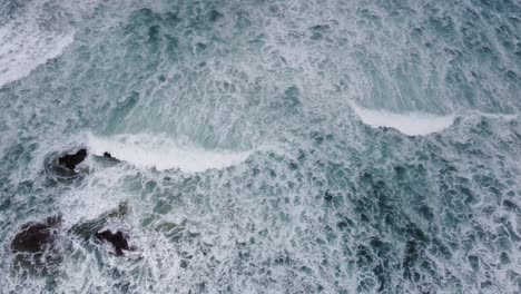 An-arial-shot-of-waves-crashing-on-rocks