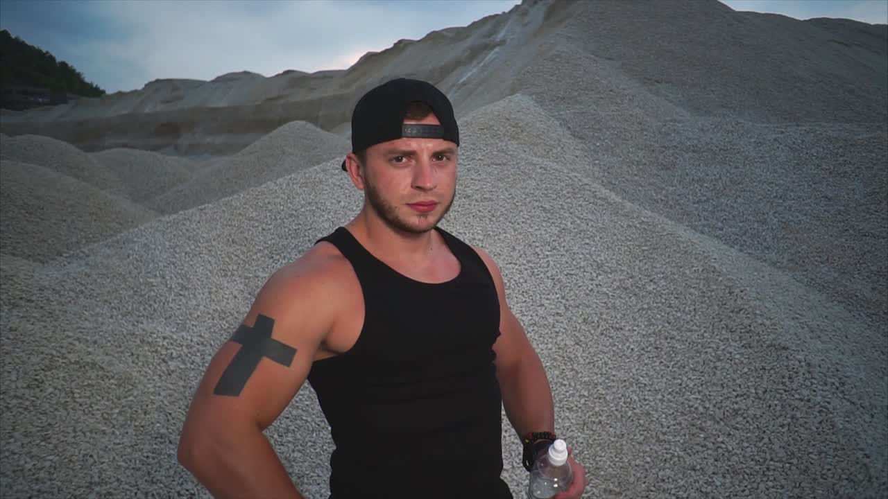 Man with Tattoo in Gravel Pit