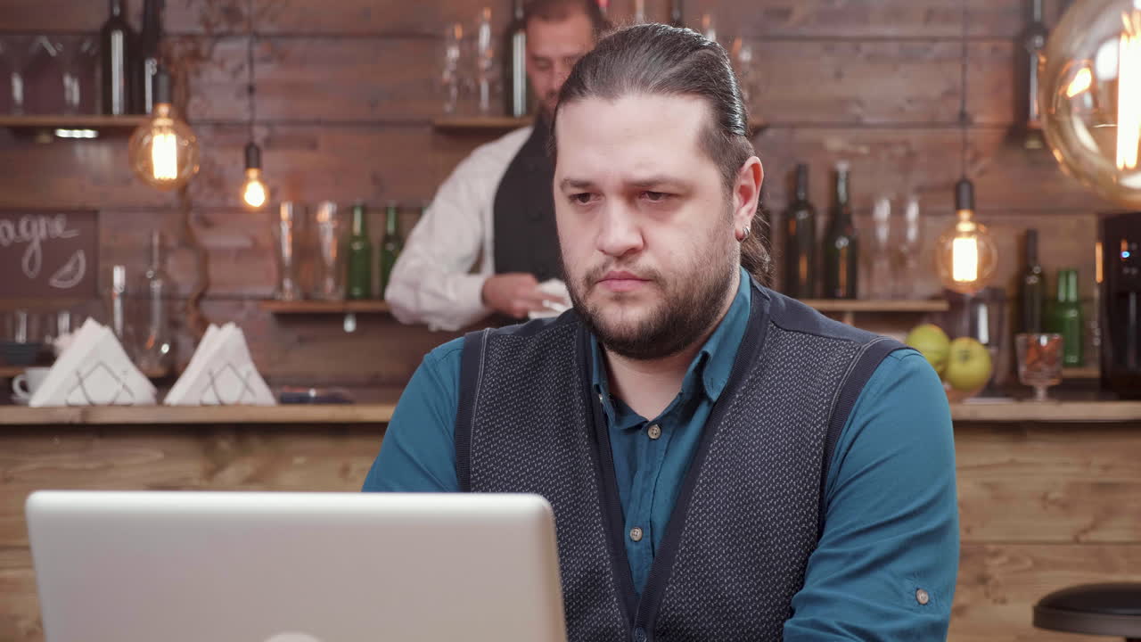 Man Working on Laptop in Bar