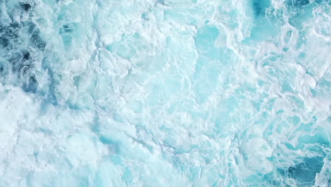 aerial: top down shot of powerful waves crashing on rocky coastline